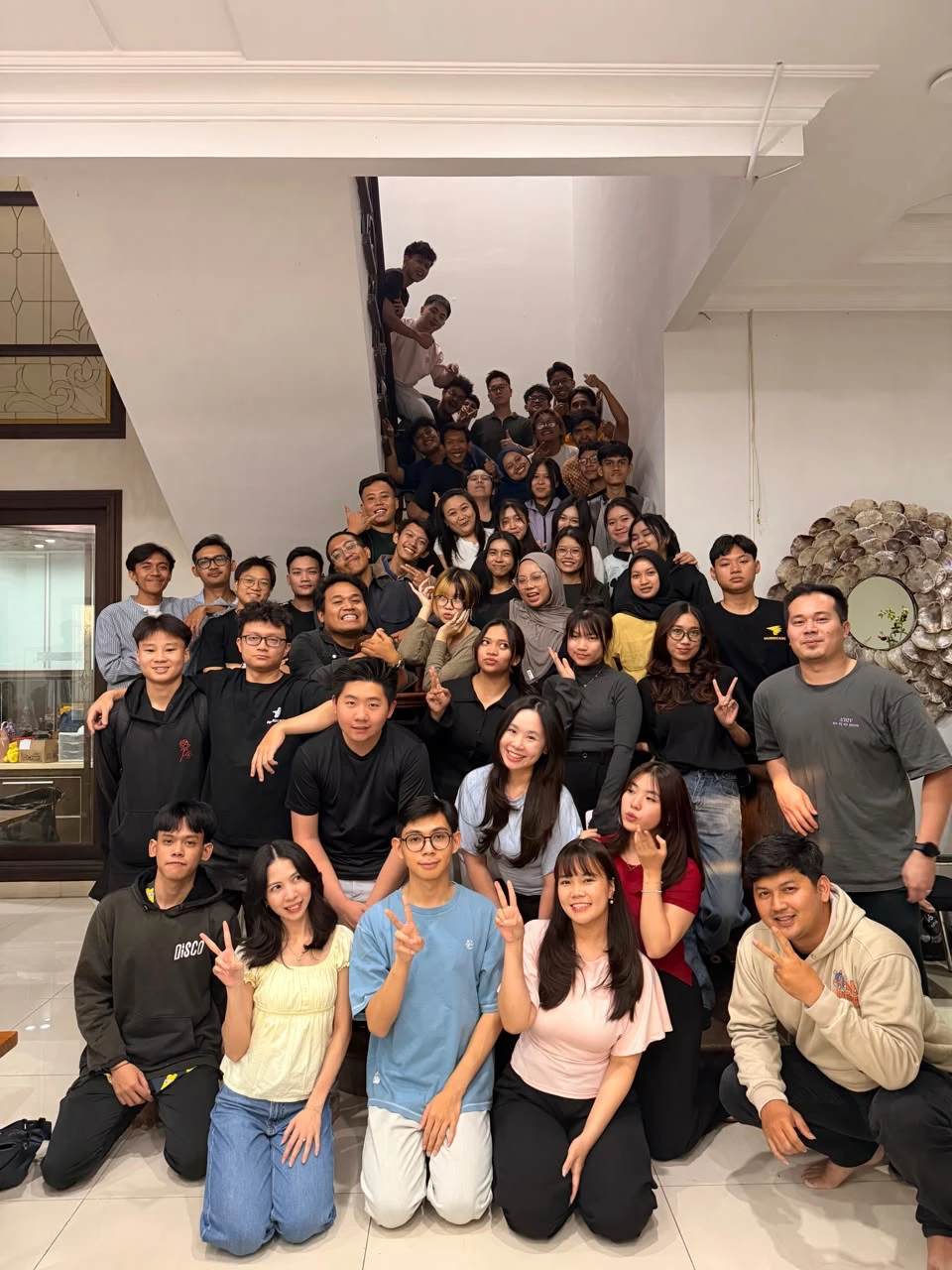Tim kami berfoto bersama di tangga kantor